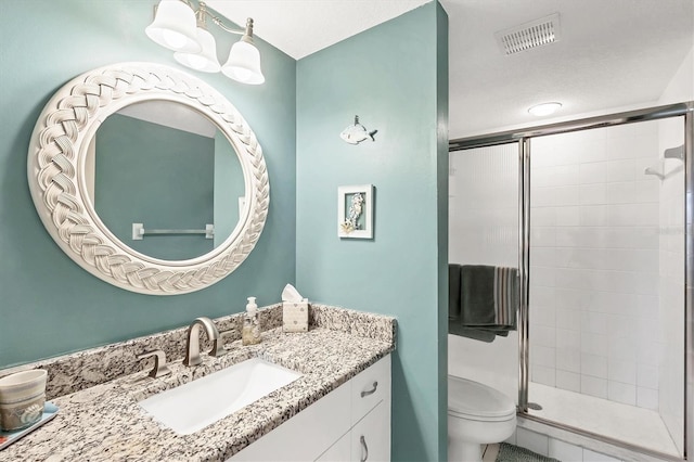 full bathroom with vanity, toilet, visible vents, and a stall shower