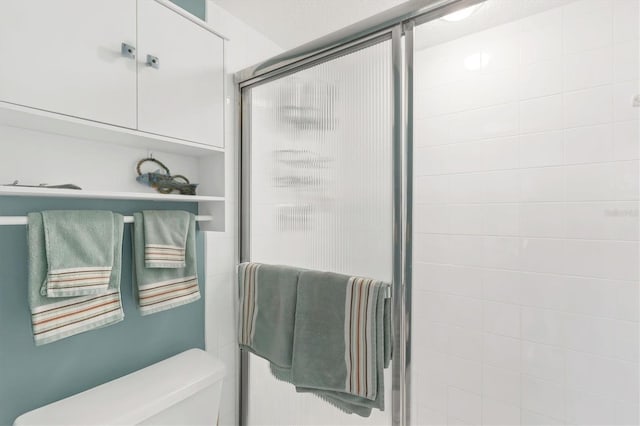 bathroom featuring a shower stall and toilet