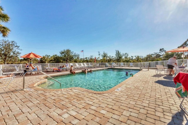 community pool with fence and a patio area