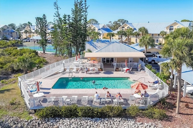 community pool featuring a residential view, a patio, and fence