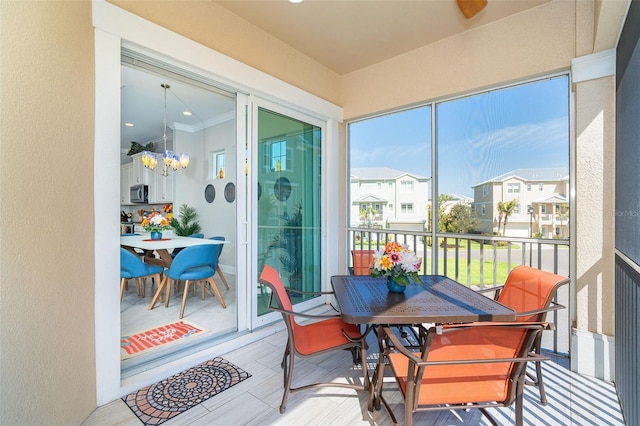 sunroom / solarium featuring a chandelier and a residential view