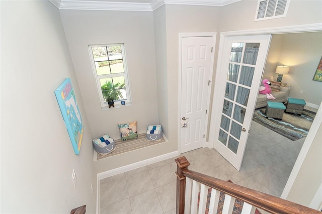 interior space featuring baseboards, visible vents, crown molding, and tile patterned floors