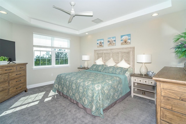 carpeted bedroom featuring visible vents, baseboards, a raised ceiling, ceiling fan, and recessed lighting