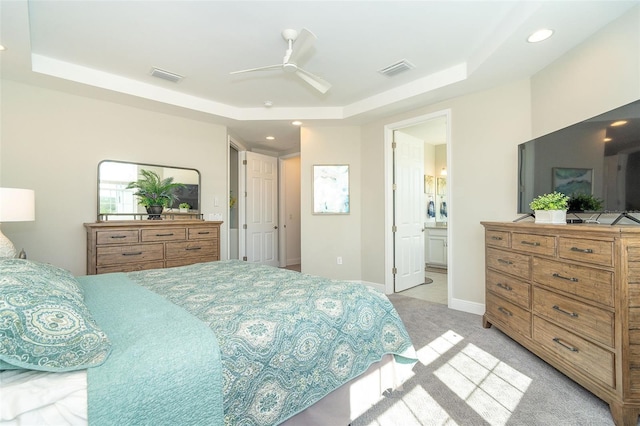 bedroom with light carpet, a raised ceiling, visible vents, and baseboards