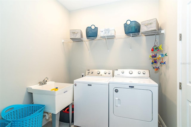 clothes washing area featuring a sink, laundry area, and washing machine and dryer