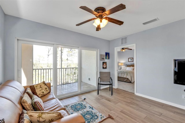 living area with a ceiling fan, light wood-type flooring, visible vents, and baseboards