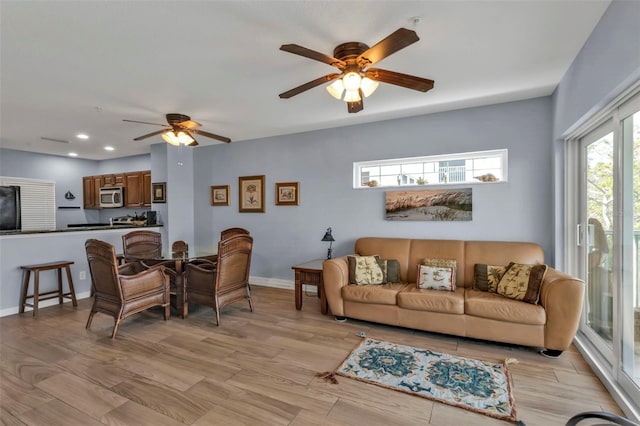 living room with a ceiling fan, recessed lighting, light wood-style flooring, and baseboards