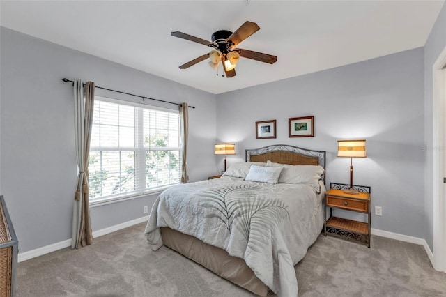 carpeted bedroom with ceiling fan and baseboards