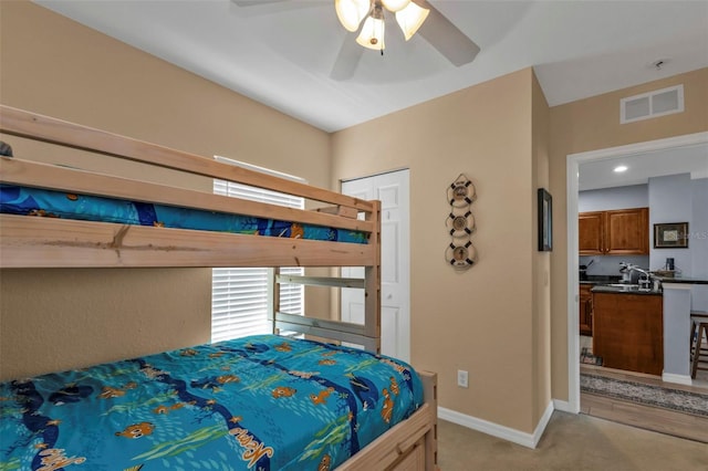 bedroom with a ceiling fan, light colored carpet, visible vents, and baseboards