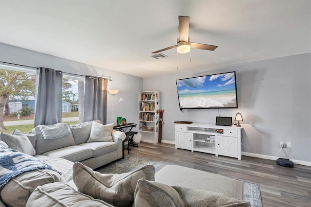 living room featuring a ceiling fan, wood finished floors, visible vents, and baseboards