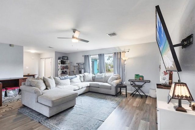 living room featuring ceiling fan, wood finished floors, visible vents, and baseboards