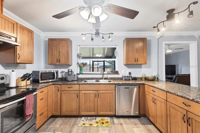 kitchen featuring stainless steel appliances, brown cabinets, a sink, and crown molding