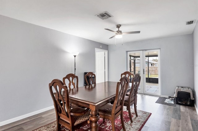 dining space with baseboards, visible vents, wood finished floors, and french doors