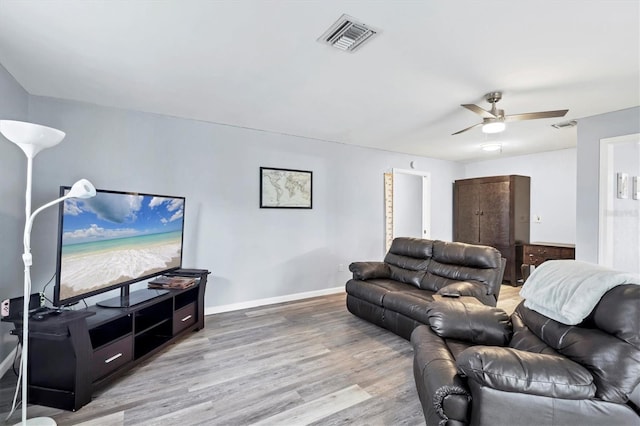 living room featuring baseboards, ceiling fan, visible vents, and wood finished floors