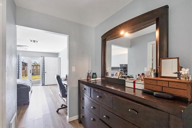 corridor featuring light wood finished floors and visible vents