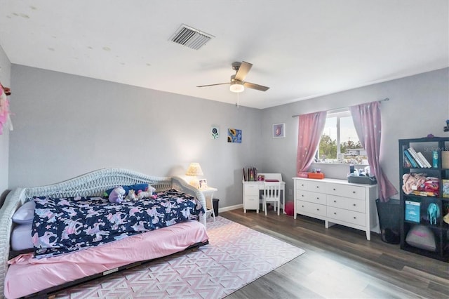 bedroom featuring baseboards, wood finished floors, visible vents, and a ceiling fan