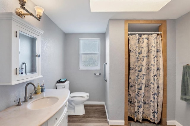 bathroom featuring baseboards, toilet, a shower with shower curtain, and wood finished floors