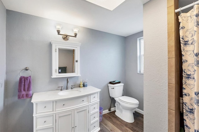 full bathroom featuring curtained shower, toilet, vanity, wood finished floors, and baseboards