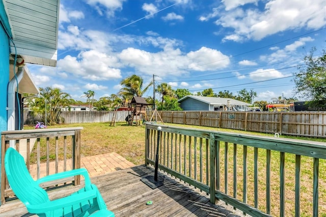 deck featuring a fenced backyard, a playground, and a lawn