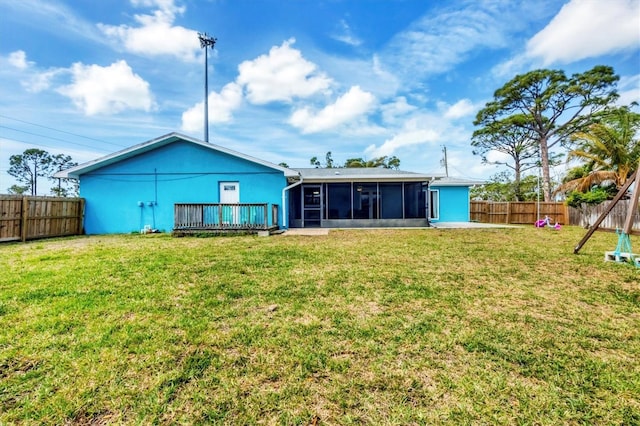 back of property featuring a sunroom, a fenced backyard, and a lawn