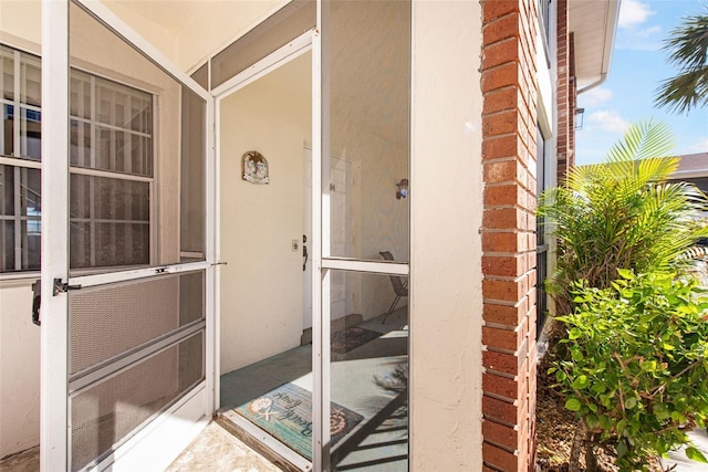 property entrance with stucco siding and brick siding