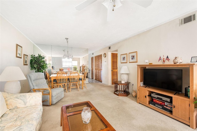 carpeted living area with crown molding, visible vents, and a ceiling fan