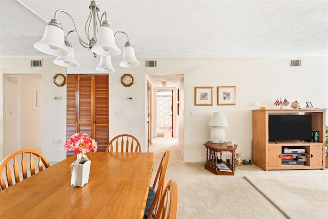 carpeted dining space featuring a textured ceiling and visible vents