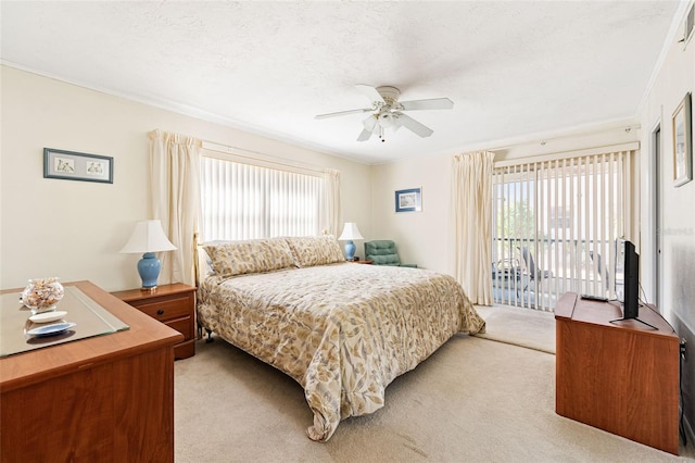 bedroom with light carpet, access to outside, multiple windows, and a textured ceiling