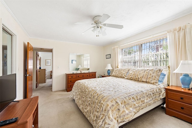 bedroom with ornamental molding, a ceiling fan, and light colored carpet