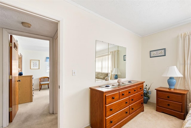 bedroom featuring ornamental molding, a textured ceiling, and light colored carpet