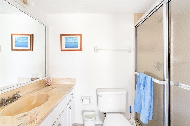 full bathroom featuring toilet, a shower stall, and vanity