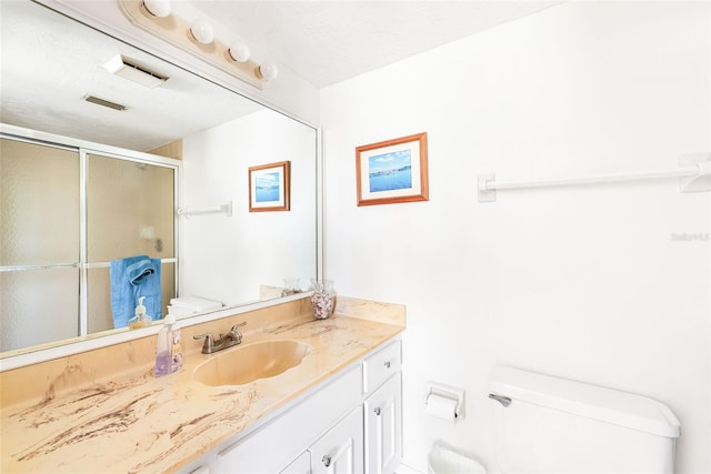 full bathroom featuring visible vents, a stall shower, vanity, and toilet