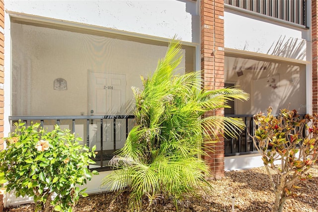 view of side of property featuring stucco siding and brick siding