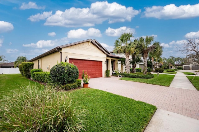 view of front facade with a garage, a front lawn, decorative driveway, and stucco siding