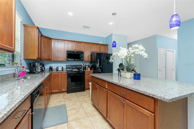 kitchen featuring light tile patterned floors, brown cabinetry, black appliances, pendant lighting, and a sink