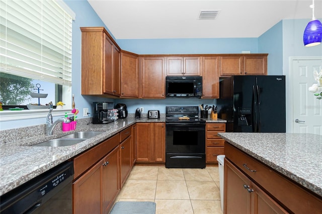 kitchen with brown cabinets, visible vents, a sink, and black appliances