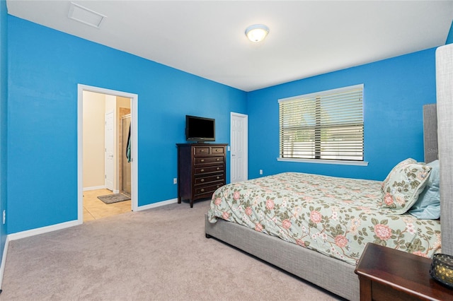 carpeted bedroom featuring visible vents, ensuite bath, and baseboards