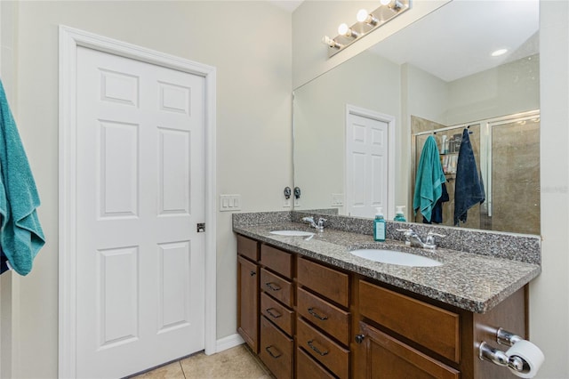 bathroom featuring double vanity, a stall shower, tile patterned flooring, and a sink