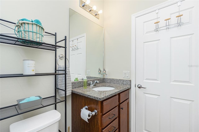 half bath featuring toilet and vanity