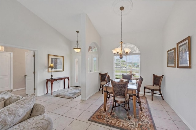 dining room with light tile patterned floors, high vaulted ceiling, baseboards, and an inviting chandelier