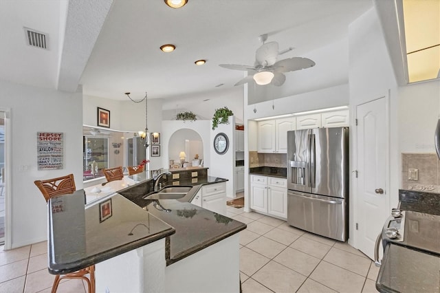 kitchen with light tile patterned floors, a sink, white cabinets, and stainless steel fridge with ice dispenser