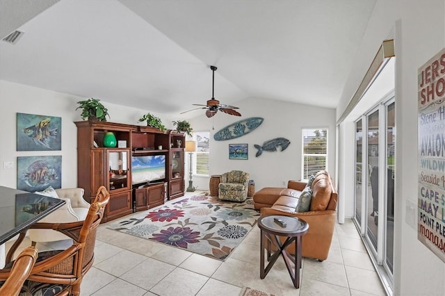 living area featuring vaulted ceiling, visible vents, plenty of natural light, and light tile patterned floors