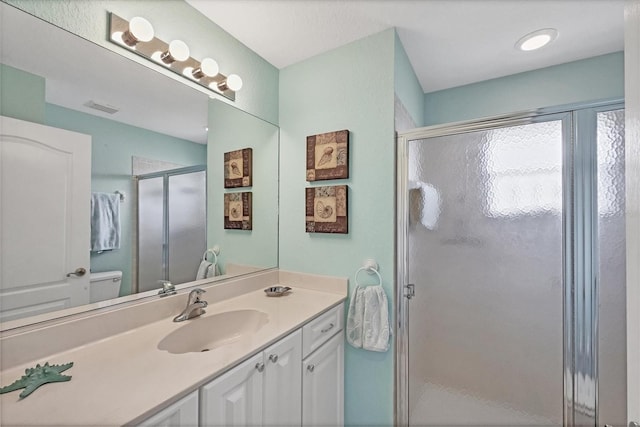 bathroom featuring visible vents, a shower stall, and vanity