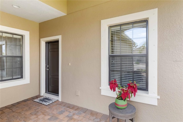 view of exterior entry with stucco siding