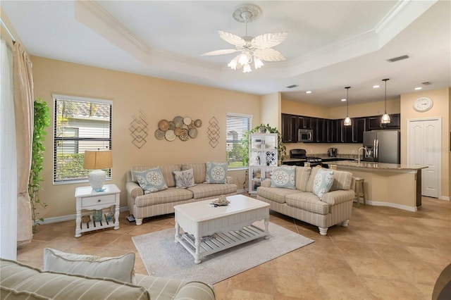 living room featuring ornamental molding, a raised ceiling, and visible vents