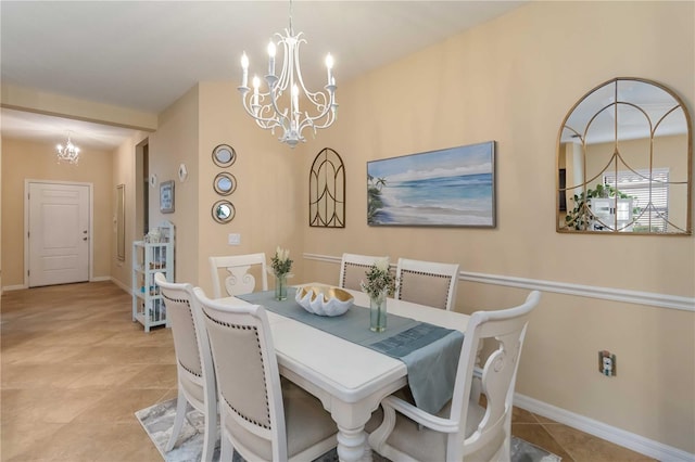 dining room with a notable chandelier, baseboards, and light tile patterned floors