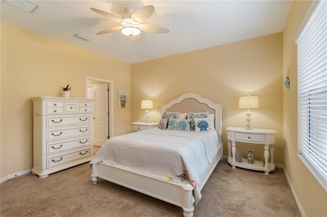 bedroom with baseboards, visible vents, and light colored carpet