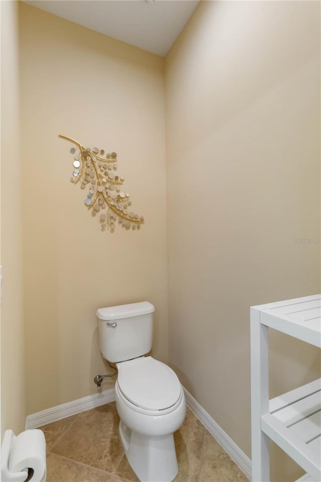 bathroom featuring tile patterned flooring, toilet, and baseboards