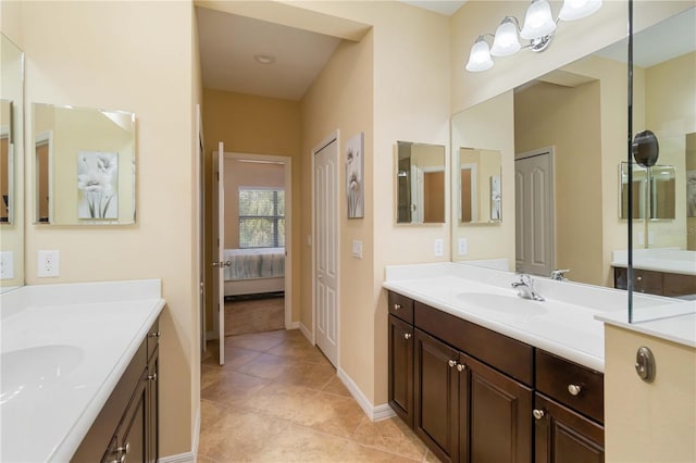 full bath with connected bathroom, two vanities, a sink, and tile patterned floors