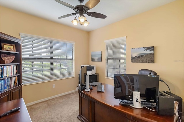 office space featuring ceiling fan, baseboards, and light colored carpet